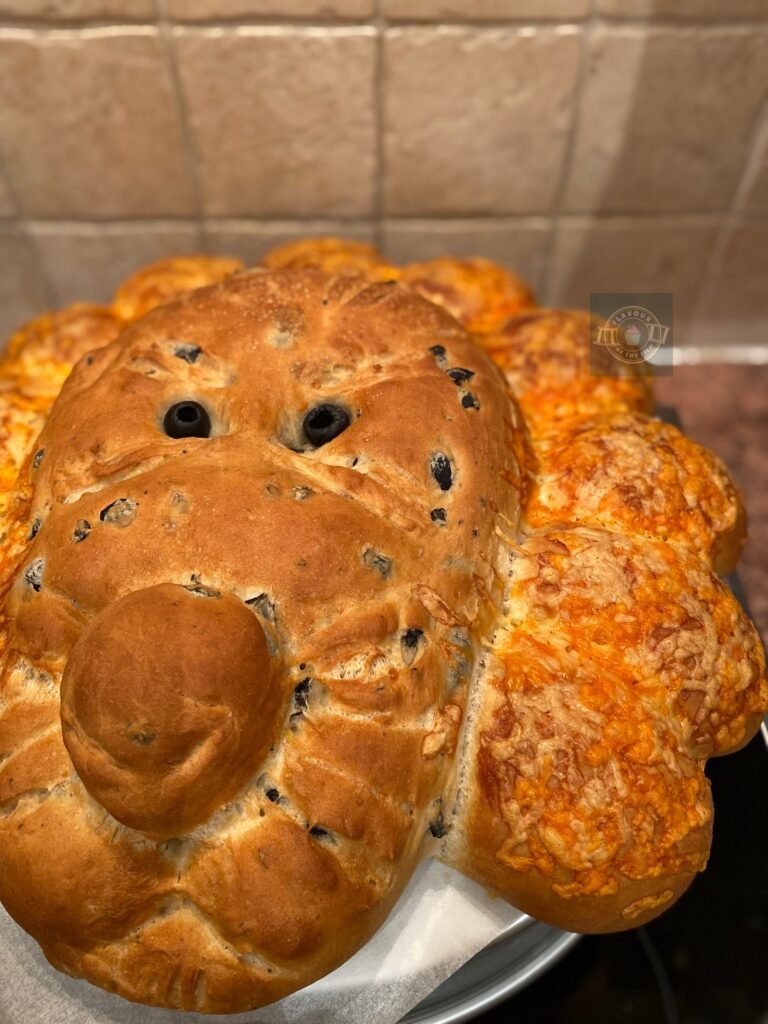 All images are of an olive bread shaped like the lion, Aslan's head, with black olive eyes; tear and share cheese rolls as his mane and a caremalised onion loaf shaped like an open book.