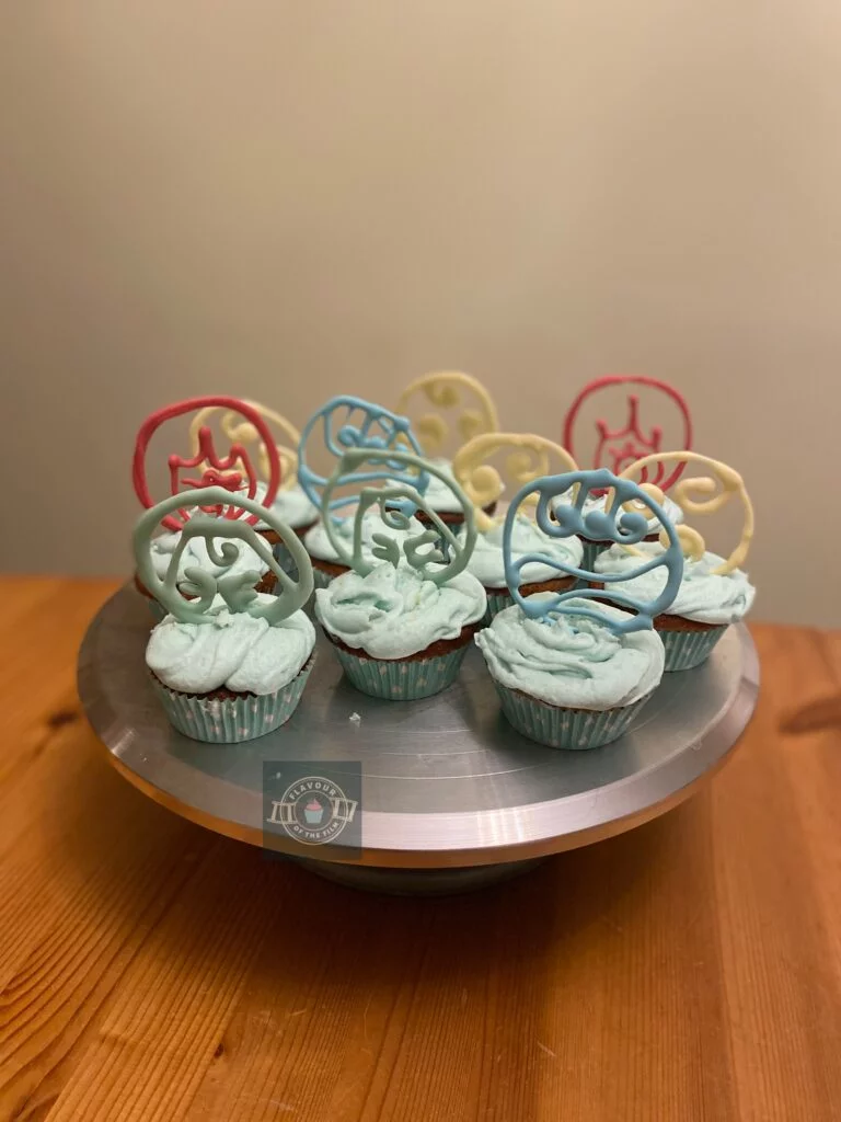 All images are of coconut flavoured Avatar The Last Airbender cakes in mint green and white polkadot cupcake cases, topped with pale green buttercream and tempered white chocolate decorations each in different colours and insignias to represent the different element nations in Avatar: The Last Airbender.