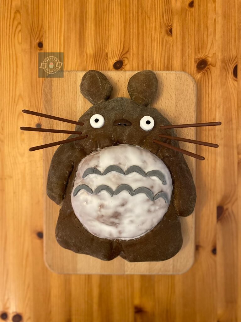 Cinnamon bread loaf in the shape of Anime character Totoro, with fondant features, Pocky whiskers and an iced belly. This bread loaf celebrates My Neighbor Totoro.