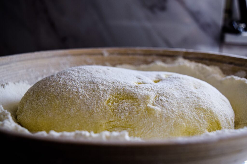 The image is a close up of a load of bread dough rising on a piece of cloth whilst in a sourdough basket.