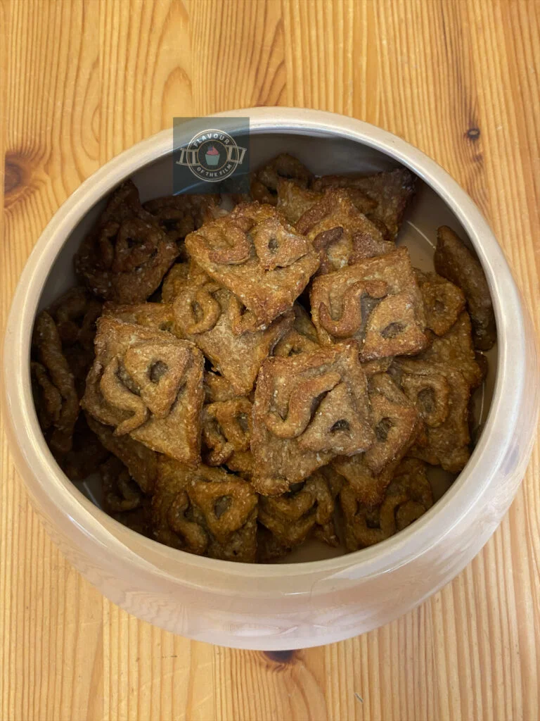 All images are of a dog bowl full of scooby snacks in the shape of Scooby-Doo's diamond collar tag. Some photos include the author's hand holding up individual treats.