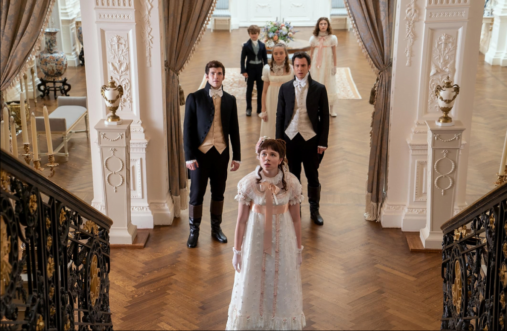 The Bridgerton siblings waiting in the entrance hall for Daphne to descend the stairs, ready for her societal debut.