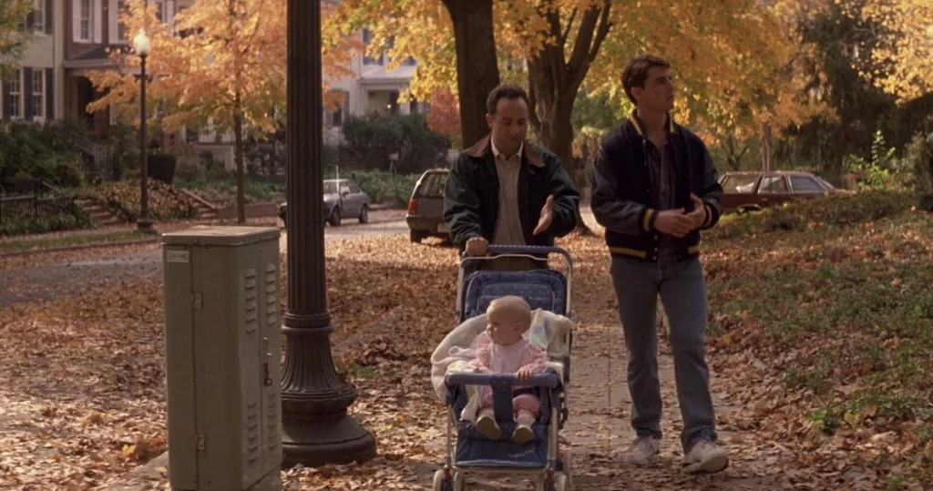 Sam and Daniel walking along an autumnal street with Sam's daughter in a stroller.