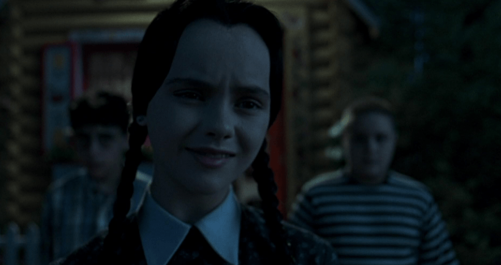 Wednesday Addams forcing a smile.