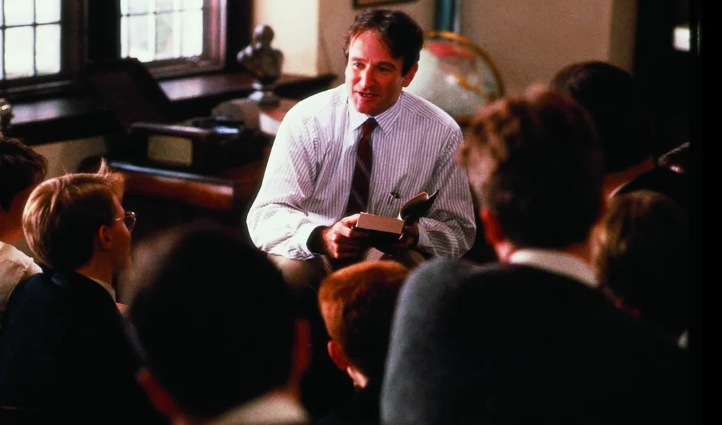 John (Williams) teaching his students whilst perched on a desk.