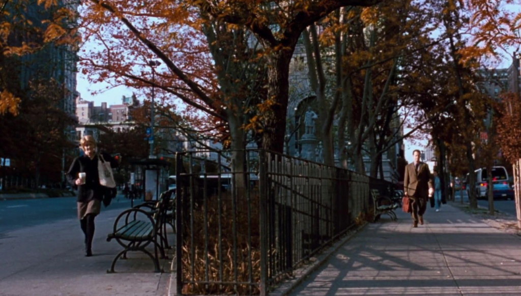 New York in the autumn with the main characters walking parallel to each other along the street.