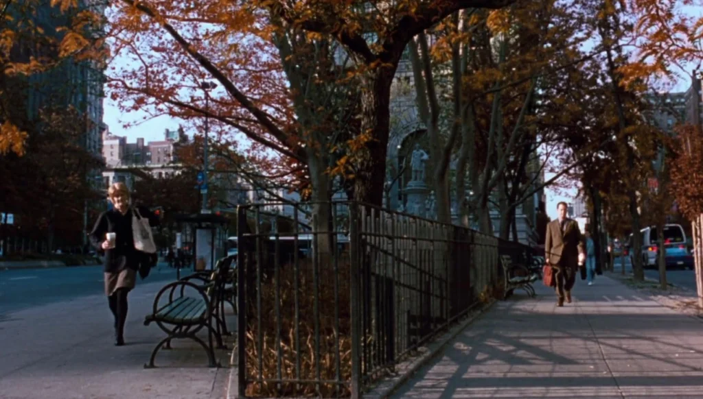 New York in the autumn with the main characters walking parallel to each other along the street.