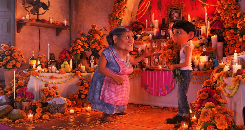 Miguel and his Abuelita standing next to their decorated family ofrenda.