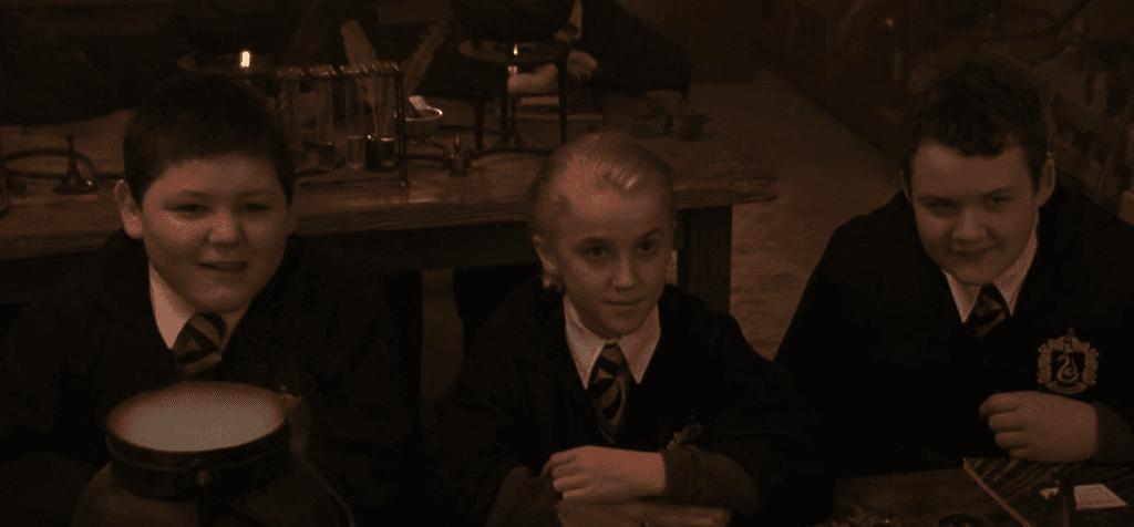 Malfoy, Crabbe and Goyle listening to Professor Snape during their first Potions lesson.