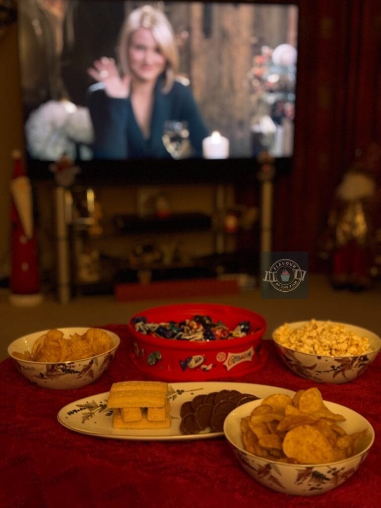 Christmas movie night ideas snack spread with The Holiday on in the background.