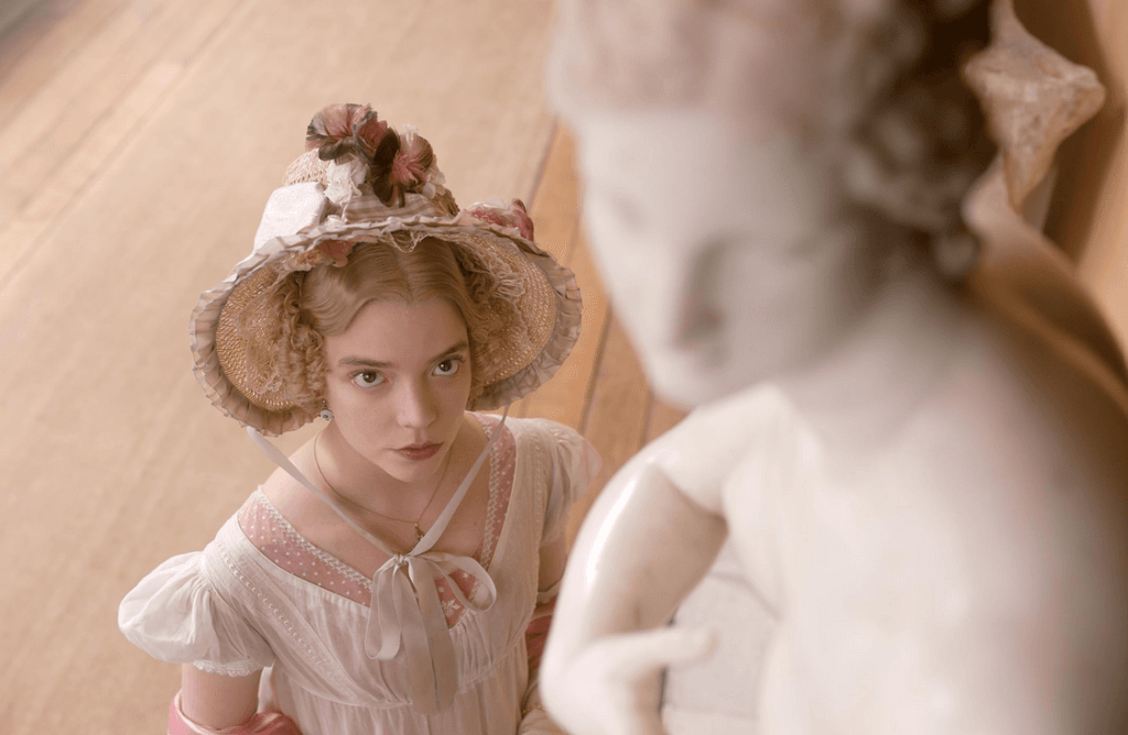 Emma staring at a marble statue, wearing white and pink.