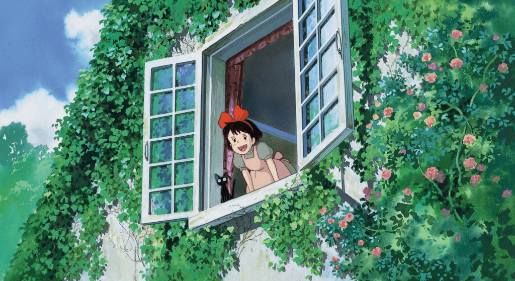 Kiki and her cat calling out the window with flowers all around.