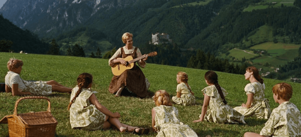 Julie Andrews singing with the kids on a hill.