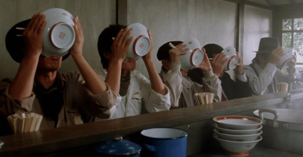 Customers slurping noodles from their bowls.