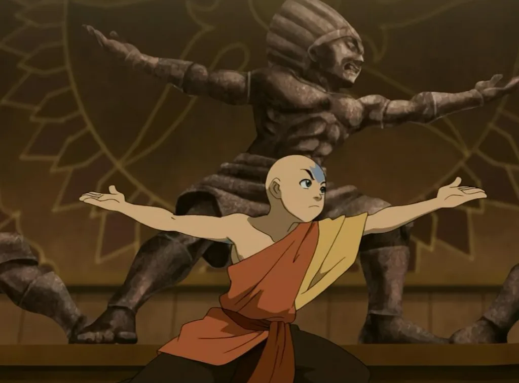 Aang in the same warrior 3 pose as the statue behind him.