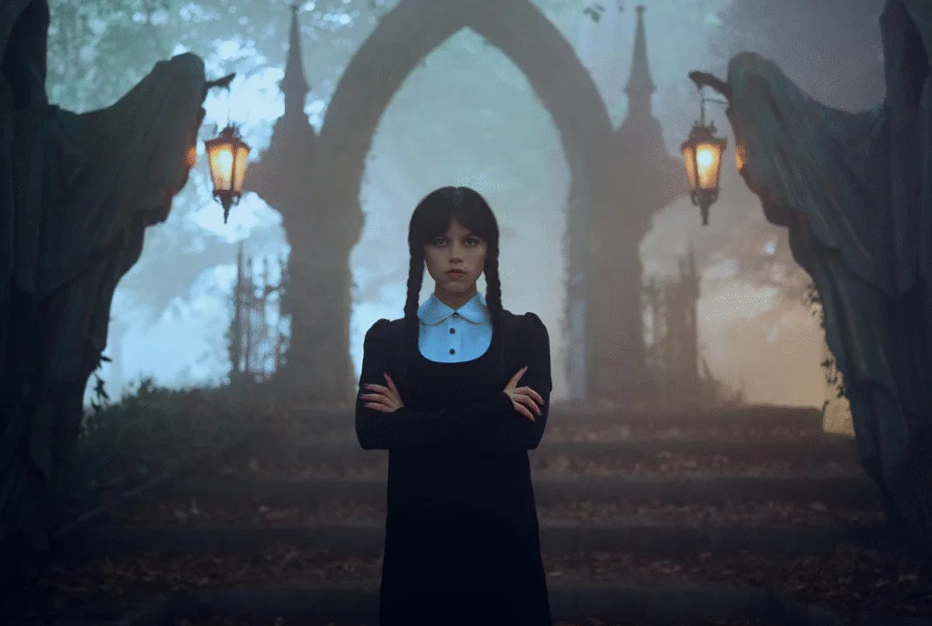Wednesday standing in a graveyard.