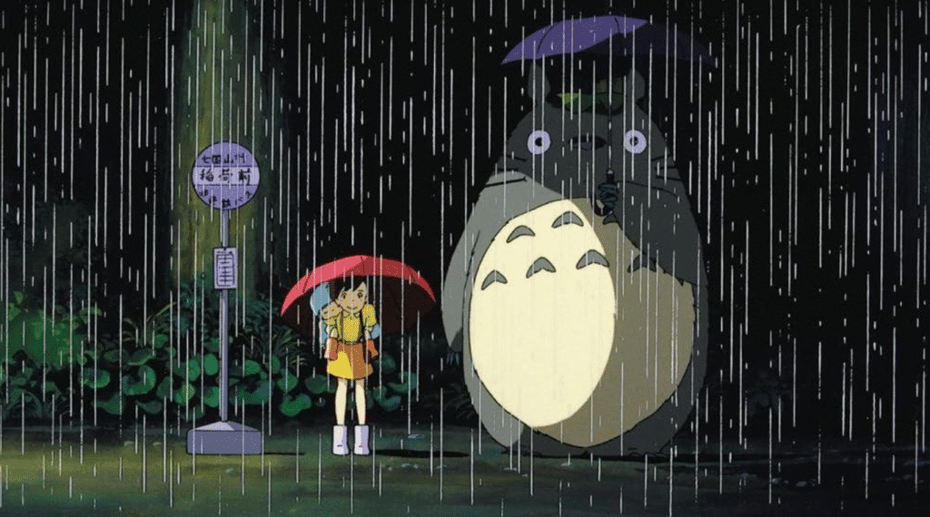 The girls standing in the rain with Totoro at the bus stop.