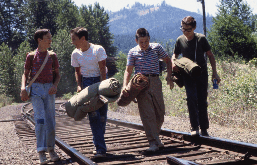 The main characters walking along a train track.