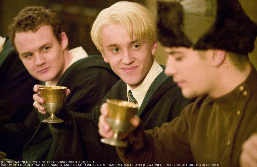 Malfoy staring at Krum in awe while they drink pumpkin juice.