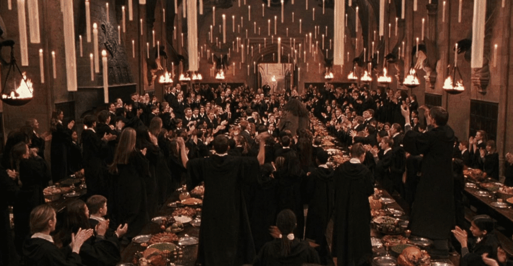 Everyone cheering upon Hagrid's return in the Great Hall.