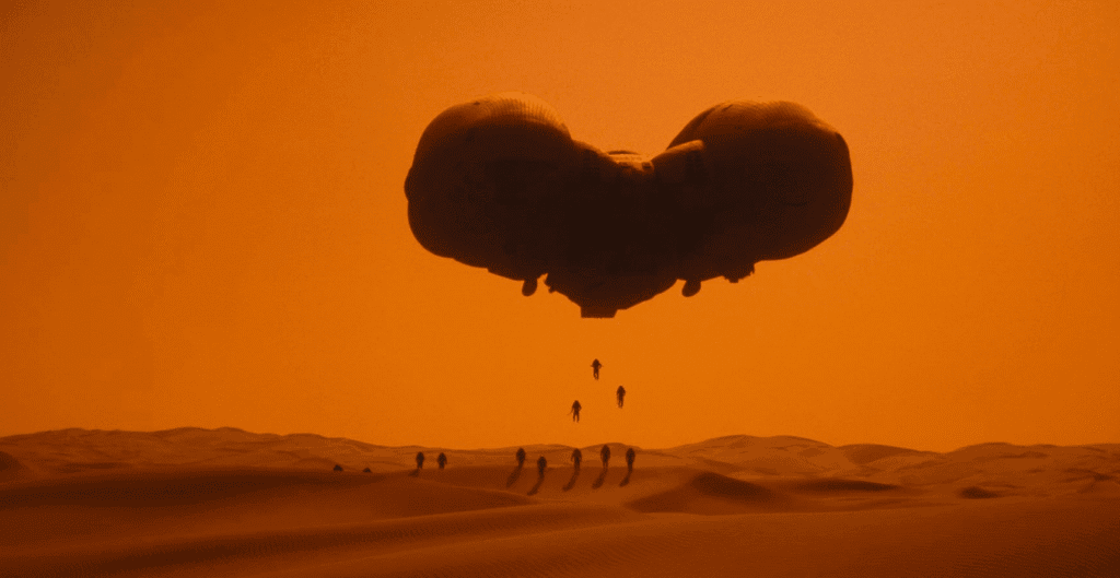 Soldiers landing in the dunes from a ship.