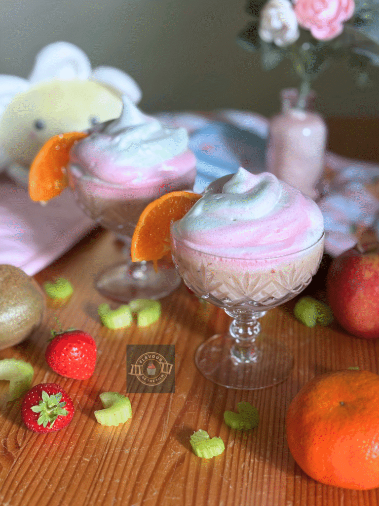 All images are of two glasses containing a pale pink smoothie, topped with a slightly glittery white, green and pink meringue swirl each. Each glass is also adorned with a slice of orange on the edge. Props include pink flowers in a small pink vase; a white and yellow flower plushie, peach print pink oven gloves, a Hello Kitty hairbrush, Cinnamoroll material fan, and the fruit and veg that this My Melody smoothie contains.